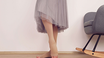 Frau trägt Kompressionsstrümpfe diese zählen zu den Heilmittel.