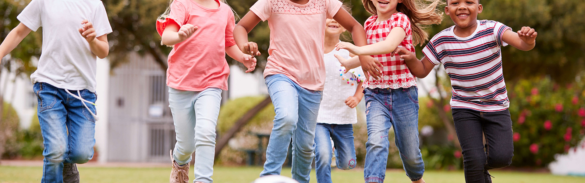 Zur Stärkung des Immunsystems bei Kindern rennen ein paar Mädchen und Jungen einem Fußball hinterher