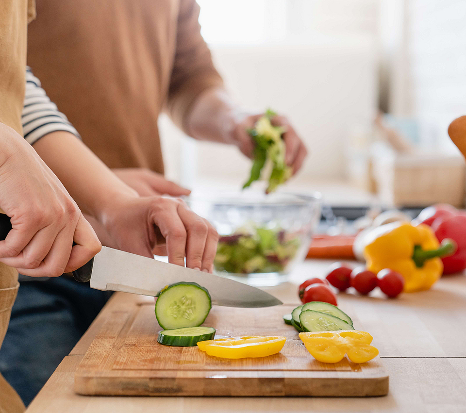 Menschen schneiden Gemüse für vegetarische Ernährung