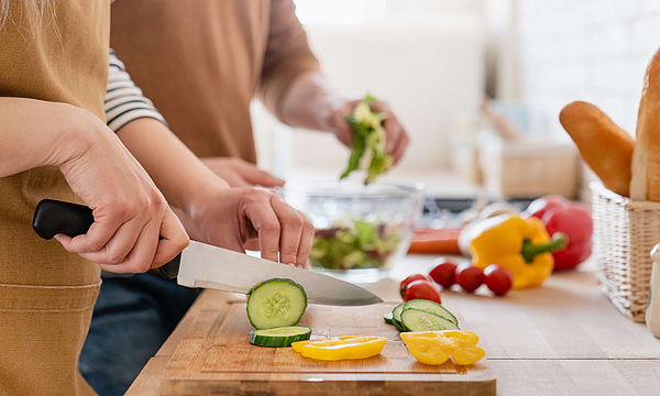 Menschen schneiden Gemüse für vegetarische Ernährung