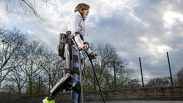 Die Frau kann mit Hilfe des Exoskeletts wieder laufen.
