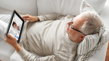 Mann lässt sich online vom Arzt über die TeleClinic beraten.