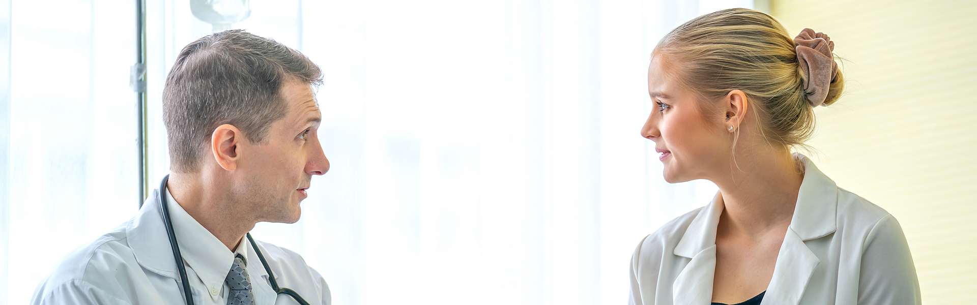 Frau spricht mit Arzt und will an den Vor- und Nachsorgeprogramme für Erwachsene teilnehmen.