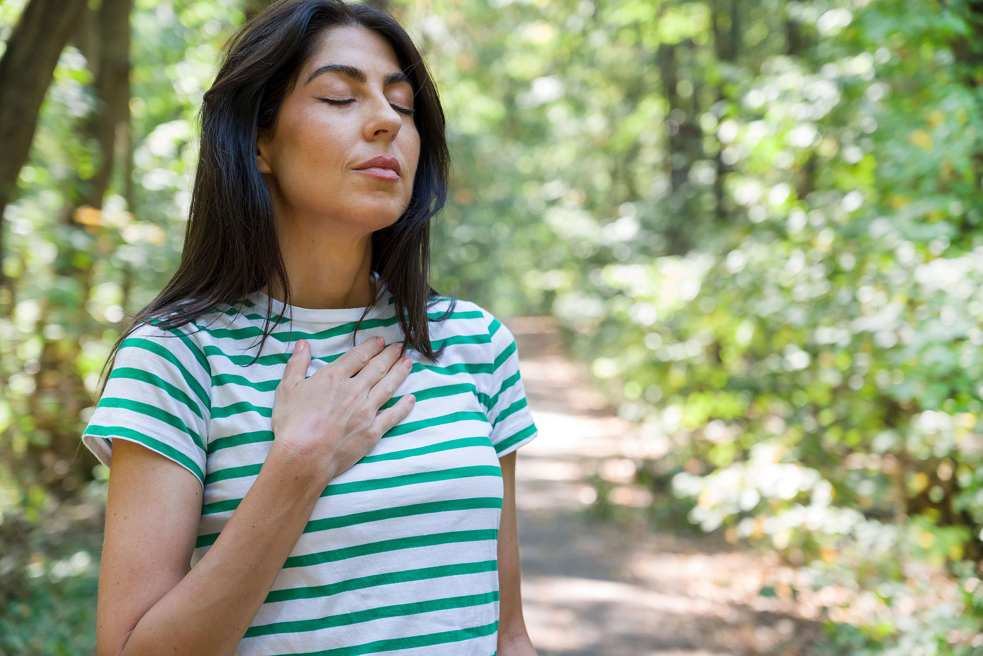 Frau macht im Wald Atemübungen