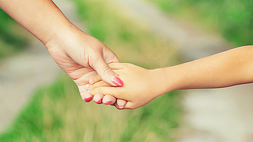 Händchenhalten, mit der Sozialmedizinische Nachsorge unterstützt die mhplus schwer kranke Kinder.