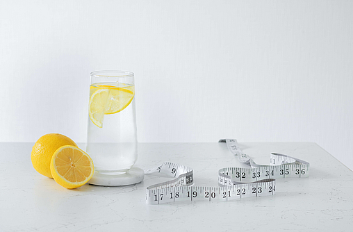  Maßband und Zutaten für Zitronenwasser zum Abnehmen