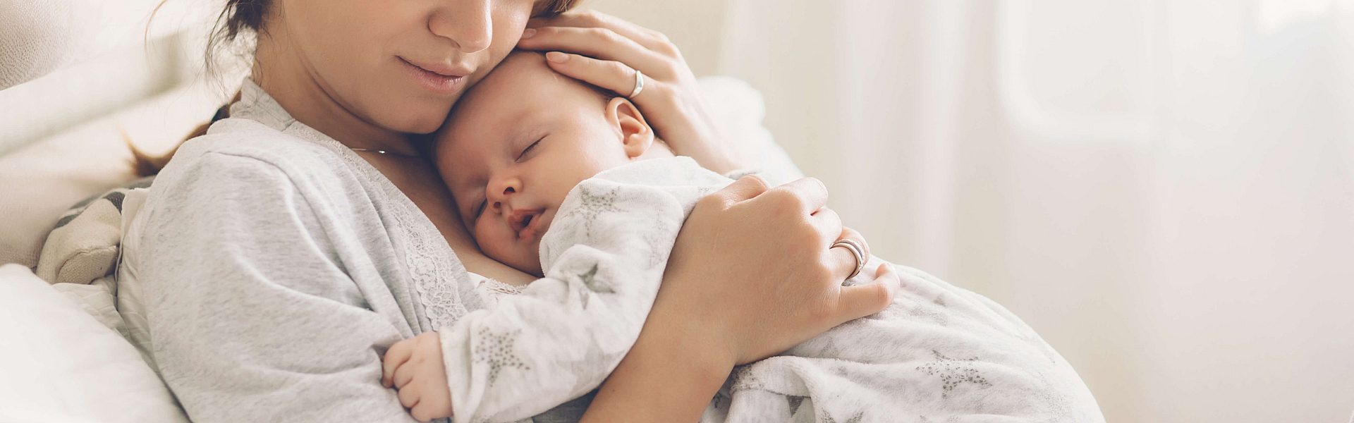 Mutter und Säugling im Bett, die ersten 6 bis 8 Wochen nach der Geburt werden als Wochenbett bezeichnet