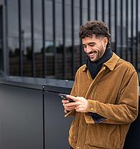 Junger Mann mit Handy in der Hand - mhplus Newsletter