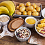 Auf einem Tisch liegen Lebensmittel mit Kohlenhydraten z.B. Banane, Kartoffeln, Hülsenfrüchte